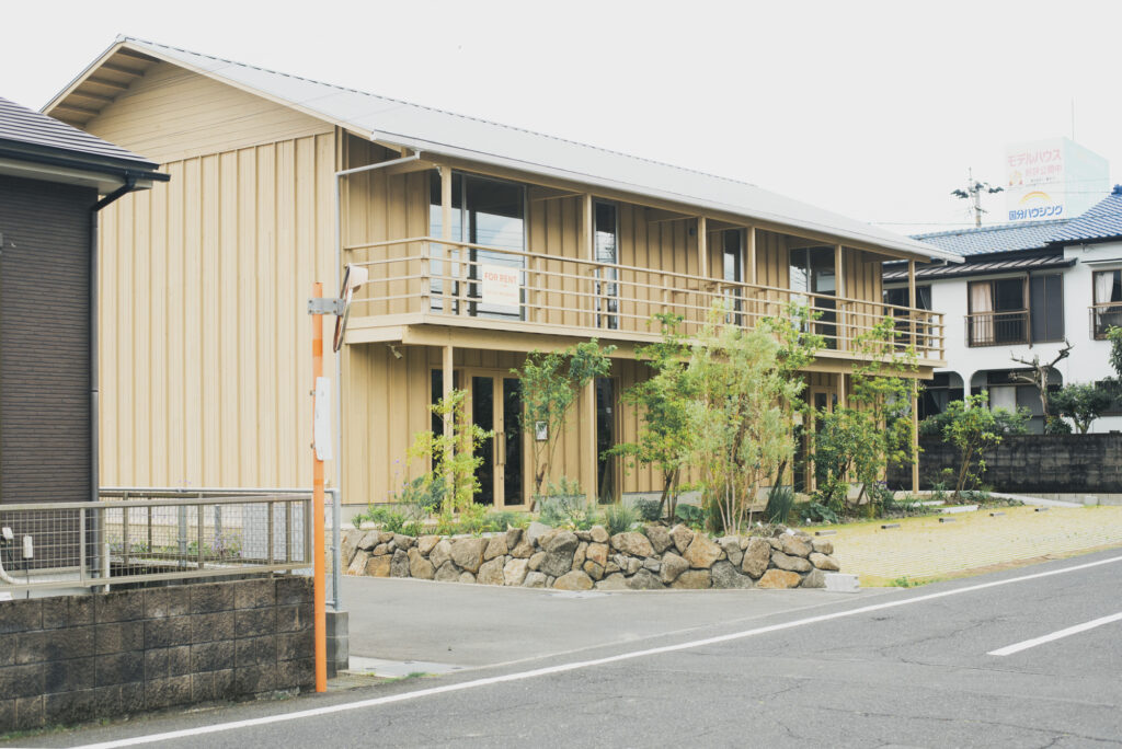 木の外壁と植栽が印象的なCUCCOU外観